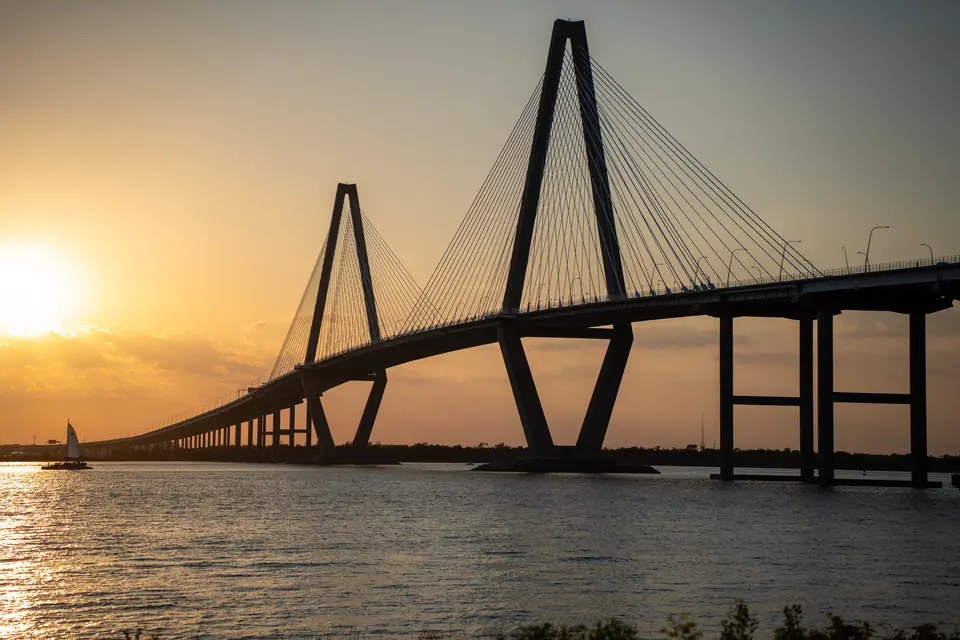 A sailboat on the Cooper River in front of the Ravenel Bridge at golden hour, Charleston, SC
